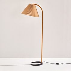 a lamp that is on top of a white table next to a black corded light