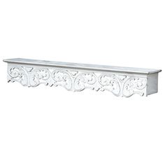 a white shelf with an ornate design on the top and bottom, against a white background