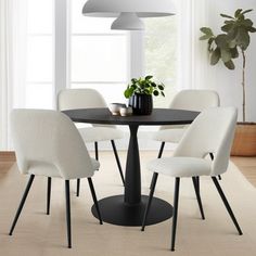 a dining room table with four chairs and a potted plant on the top of it