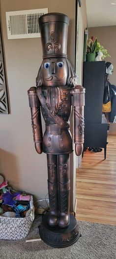 a large metal nutcracker statue sitting on top of a wooden floor