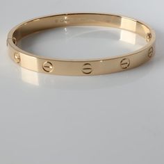 Cartier Love Bracelet (Yellow Gold)  PRIMARY DETAILS  SKU: 141862  Listing Title: Cartier Love Bracelet (Yellow Gold)  Condition Description: Cartier's Love collection is the epitome of iconic, from the recognizable designs to the history behind the line-up. The collection started in 1969 with the bangle bracelet, which is engraved with a circular motif throughout to mimic the look of the bracelet's signature screw-lock mechanism.     Retails for 7350 USD. In excellent condition. 17 in length. Comes with Box;Pouch;Screwdriver;Service Papers;  Brand: Cartier  Collection/Series: Love  Metal Type: Yellow Gold  Metal Purity: 18k  Chain or Bracelet Length (in): 17  Pre-Owned Jewelry Condition: Excellent  SIDE STONE INFORMATION  Original Box?: Yes  Original Papers?: No  This item has been used a Cartier Gold Bracelet, Screw Bangles Gold, Luxury Gold Hallmarked Bangle, Luxury Polished Yellow Gold Bangle, Luxury Gold-tone Bangle Bracelets, Gold-tone Luxury Bangle, Luxury Gold-plated Bangle With Polished Finish, Cartier Love Collection, Cartier Bangle