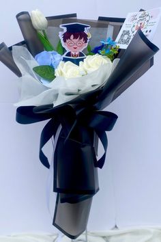 a bouquet of flowers is wrapped in black paper and tied to a metal pole with an image of a boy on it