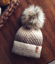 a white and gray hat sitting on top of a wooden floor