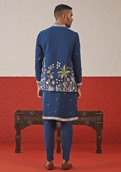 Elevate your style with Blue Jacket kurta set. Crafted from georgette, the jacket showcases exquisite resham and sequinned embroidery. The kurta features a detailed collar, cuffs, and yoke design, plus two pockets and pure lining. Paired with intricately embroidered pants for a touch of elegance. Perfect for special occasions like Sangeet, Mehendi, or as a wedding guest outfit. Composition : Jacket, Kurta & Trouser : Viscose Georgette Care: Dry Clean Only and Vacuum Storage This product can be c Formal Blue Nehru Jacket With Resham Embroidery, Festive Blue Nehru Jacket With Intricate Embroidery, Festive Embroidered Blue Nehru Jacket, Fitted Blue Embroidered Nehru Jacket, Ceremonial Blue Embroidered Nehru Jacket, Kurta Set With Jacket, Yoke Design, Vacuum Storage, Embroidered Pants