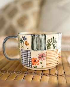 a close up of a coffee cup on a table with a basket in the background