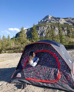 a woman sitting in a tent on the ground