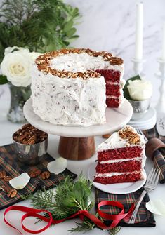 a red velvet cake with white frosting and pecans on the side, surrounded by other desserts