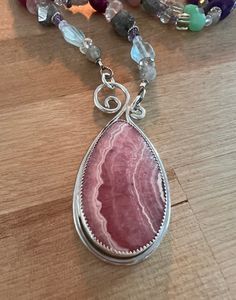 "This is a gorgeous cabochon of rhodochrosite which I have paired with sterling silver.  The chain is multi gem and sterling silver and is adjustable from 25\" to 27\".    If you are interested in purchasing just the pendant, send me a message." Pink Cabochon Necklaces For Jewelry Making, Silver Rhodonite Jewelry With Natural Stones, Pink Sterling Silver Necklace With Large Pendant, Silver Tourmaline Necklace With Natural Stones, Silver Jewelry With Natural Stones And Rhodonite, Silver Tourmaline Necklaces With Natural Stones, Pink Natural Stones Gemstones In Sterling Silver, Unique Silver Tourmaline Necklace, Pink Sterling Silver Jewelry With Large Pendant