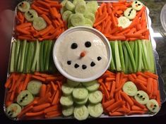 carrots and celery arranged in the shape of a snowman's face