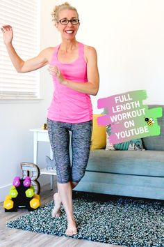 a woman in pink shirt and leggings standing next to a couch with sign that says full length workout on youtube