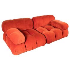 an orange couch sitting on top of a white floor