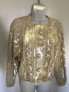 VTG 80's "Destinee" Cardigan Sequin Long Sleeve ivory Wool Acrylic Blend Sweater. Irridescent sequins. Snap front and covered buttons with sequins. Tag says small but seems larger. Check measurements. Cream Formal Cardigan For Fall, Beige Winter Party Sweater, Formal Cream Cardigan For Fall, Gold Cardigan For Winter Party, Cream Formal Cardigan For Winter, Elegant Gold Sweater For Winter, Elegant Gold Winter Sweater, Gold Cardigan For Fall Party, Chic Gold Cardigan For Winter