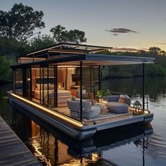 a houseboat floating on top of a body of water next to a dock at sunset