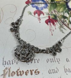 Vintage 1950's -1960's silver tone and marcasite necklace. An original vintage silver tone necklace set with sparkling marcasites. A very pretty, floral design. The chain is a fancy flat link design with a spring ring fastener.  What is marcasite? - Marcasite is a faceted grey stone called pyrite. All the stones are present but as a preloved piece , will show slight signs of wear relative to its age.  Approximate measurements  Length 15.5  inches / 39.5 cm Centre section 3 inches / 7.5 cm Vintage and preowned jewellery is another way to reduce your carbon footprint.  Postage will be combined for purchases made in the same transaction. The necklace will be gift boxed. Silver Jewelry With Intricate Design For Vintage Events, Silver Victorian Necklace For Vintage Events, Victorian Silver Necklace For Vintage Events, Silver Jewelry With Jewels For Vintage Events, Ornate Silver Necklaces For Vintage Events, Silver Jeweled Jewelry For Vintage Events, Silver Pendant Necklace For Vintage Events, Silver Filigree Jewelry For Vintage Events, Silver Jewelry With Vintage Charm For Vintage Events