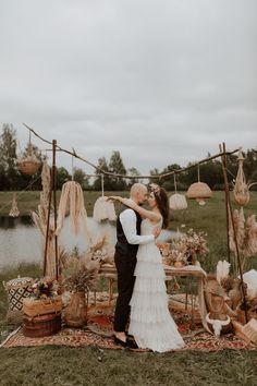 a bride and groom kissing in front of an outdoor wedding ceremony setup with umbrellas