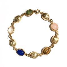 Finely detailed vintage gold gilt scarabs with hieroglyphs combine with vintage gemstone scarabs in this stunning dainty bracelet found only at Mas Collected. View all photos for close ups of the incredible detail. Makes a great gift idea for her!  Scarabs are considered to signify self transformation, new beginnings and good luck. Whether for you, or someone you love, welcome the season with our own in house designed limited quantity scarab gold filled bracelet!  Gemstone scarabs are hand set i Heirloom Gold Bracelets With Multi-stone, Heirloom Gold Multi-stone Bracelets, Gold Oval Bohemian Bracelets, Bohemian Gold Oval Bracelets, Antique Gold Bracelets With Cabochon, Antique Gold Cabochon Bracelets, Vintage Yellow Gold Bracelets With Jewels, Vintage Yellow Gold Bracelet With Jewels, Vintage Yellow Gold Cabochon Bracelets