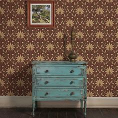 a blue dresser sitting in front of a wall with a painting on top of it