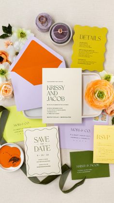 the wedding stationery is laid out on top of each other with flowers and candles