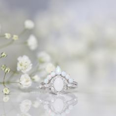 The Beautiful Dreamer ring is inspired by the 1864 song called "Beautiful Dreamer." The alternating marquise and round stone halo design is reminiscent of the graceful curves of a flower blooming. The ring has a dreamy and ethereal aesthetic, but is also classic and timeless. Delicate White Oval Diamond Ring, Delicate Oval White Diamond Ring, White Marquise Diamond Ring With Gemstone, Elegant Teardrop Stackable Rings, White Cluster Rings With Rose Cut Diamonds, Elegant Cluster Halo Wedding Ring, Elegant White Marquise Diamond Ring, Marquise Halo Design Wedding Ring, Delicate White Moonstone Ring For Wedding