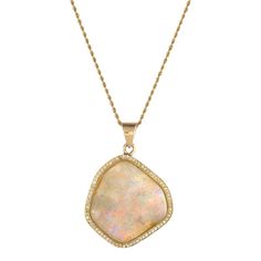 This is part of Chairish’s Fine Jewelry assortment.  Stylish opal & diamond pendant, crafted in 18 karat yellow gold (pendant) and 14 karat yellow gold (chain).    A large natural freeform opal measures 26mm x 24mm and is framed with 75 round brilliant cut diamonds that total an estimated 0.37 carats (estimated at H-I color and VS2-SI1 clarity). The opal is in very good condition and is free of cracks or chips.     The contemporary pendant is designed in a freeform mounting to mirror the shape o Luxury Opal Pendant Necklace, Luxury Opal Necklace With 17 Jewels, Yellow Gold Opal Pendant Necklace, Opal Pendant Necklace With Large Pendant, Elegant Opal Necklace With Large Pendant, Luxury Gold Opal Necklaces, Luxury Yellow Gold Opal Necklace, Luxury Gold Opal Necklace, Contemporary Pendant