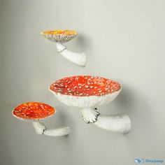 three white and red mushrooms are floating in the air on a gray background with space for text