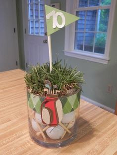 a golf themed centerpiece in a glass vase