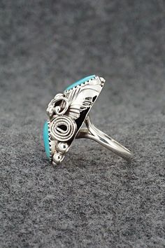 This turquoise and sterling silver ring was made by Navajo silversmith Max Calladitto. The inside of the band is signed and stamped sterling.Size: 5Length: 1 1/8"Width: 5/8"Free shipping on all orders! We ship with USPS and always include tracking. All orders ship within a day of payment.Returns are accepted up to 30 days after you receive your order. Just send us a message. Our shop offers cash back or store credit. The item must be returned in new condition. Sterling Silver Turquoise Rings With Concho Detail, Southwestern Sterling Silver Turquoise Ring For Anniversary, Unique Silver Turquoise Ring With Inlay, Sterling Silver Turquoise Ring With Concho, Sterling Silver Turquoise Concho Ring, Western Sterling Silver Turquoise Concho Ring, Unique Turquoise Ring With Concho For Gift, Artisan Silver Turquoise Ring With Inlay, Gift Turquoise Ring With Concho