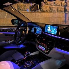 the interior of a modern car is shown with blue lights and electronic displays on the dashboard