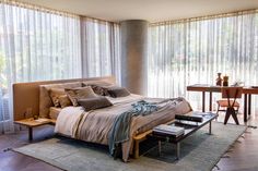 a large bed sitting in the middle of a bedroom next to a table and chairs