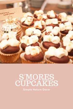 some cupcakes with marshmallows on them and a sign that says s'mores cupcakes