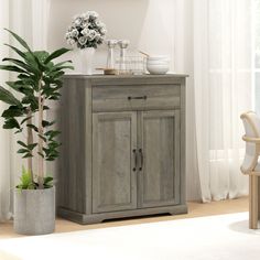 a wooden cabinet sitting next to a potted plant