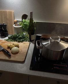 a kitchen counter top with a pot and some vegetables on it next to a cutting board