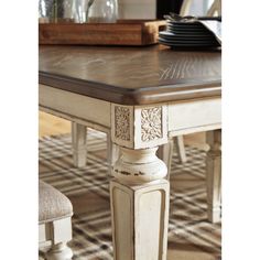 a dining room table with chairs and plates on it