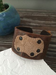 "This unique multi-color cuff bracelet is made of natural, rustic cowhide leather. I riveted a super soft piece of natural suede to the cuff for interest and detail. The riveted suede creates a \"pocket\" that will hold feathers or anything else your mind can imagine. I personally have a cuff in this style and I wear it with a feather. This cuff is ready to ship and will arrive attractively packaged and ready for gifting or for keeps. MEASUREMENTS & SPECIFICS: SIZE: one size - fits most men Adjustable Brown Leather Cuff Bracelet, Distressed Brown Leather Bracelets As Gift, Western Style Brown Cuff Bracelet As Gift, Rustic Leather Cuff Bracelet With Leather Strap, Handmade Western Brown Cuff Bracelet, Rugged Leather Bracelets, Rustic Leather Cuff Bracelet, Handmade Western Style Brown Cuff Bracelet, Distressed Brown Leather Cuff Bracelet