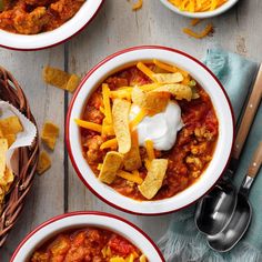 three bowls of chili with cheese and tortilla chips