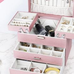 an open pink jewelry box sitting on top of a table