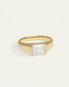 a yellow gold ring with a square diamond in the center and a single stone at the bottom