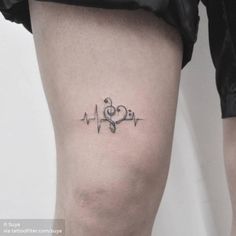 a small heartbeat tattoo on the thigh