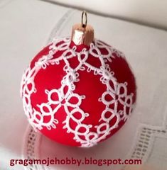 a red ornament with white lace on it