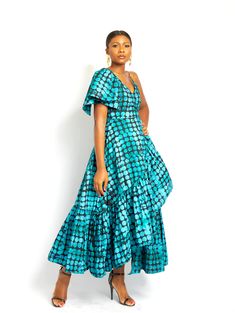 Let your hair down and feel the sun on your shoulders in the this wrap dress that keeps you flowing and flawless. Flutter cap-sleeves on one side, chain sleeve on the other. Deep V neckline, A-line maxi silhouette with a tie at the waist to cinch your silhouette. A fun batik print in hues of turquoise and black sweetly dances across to form a darted, sleeveless bodice with a ruffle-trimmed tastefully finished hemline. Mode Batik, Kitenge Designs, African Fabric Dress, Ankara Gown Styles, Batik Print, Ankara Dress, African Print Dresses, African Fashion Women, African Clothing Styles