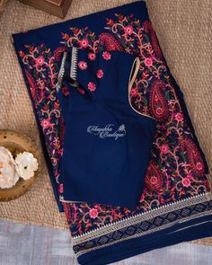 This blue saree with Kashmiri embroidery on georgette has a mesmerising beauty. The sophisticated blue body is embellished with pink-hued Kashmiri flower embroidery and accented with embroidered floral-paisley vines at the pleat ends, adding a touch of understated grandeur to the self border made of varied brocade. Alongside is a self-pleated blouse with hand embroidery. Traditional Blue Pre-draped Saree With Floral Embroidery, Unstitched Blue Pre-draped Saree With Intricate Embroidery, Blue Chanderi Pre-draped Saree With Intricate Embroidery, Blue Pre-draped Saree With Chikankari Embroidery, Blue Georgette Choli With Floral Embroidery, Blue Choli With Chikankari Embroidery For Diwali, Blue Blouse For Eid Reception, Blue Elegant Blouse For Eid, Blue Georgette Blouse Piece With Floral Embroidery