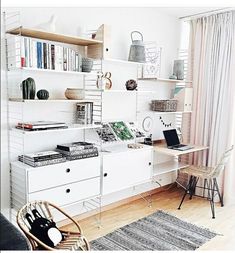 a living room with white furniture and bookshelves on the wall, along with an area rug