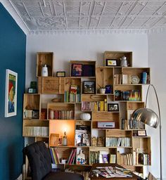 a living room filled with furniture and bookshelves next to a wall mounted lamp