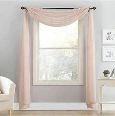 a living room filled with furniture and a large window covered in pink drapes