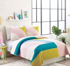 a bed room with a neatly made bed next to a window and a potted plant