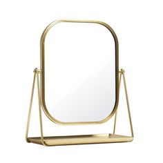 a gold metal stand with a mirror and shelf on it, against a white background