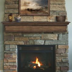 a fire place with a painting on the wall