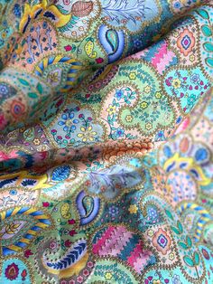 the fabric is colorful and has many designs on it's sides, including an intricate design