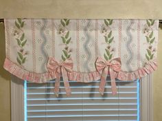 a pink bow tie valance hanging on the side of a window