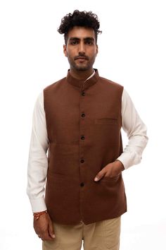 A brown woolen Nehru jacket is a fashionable and practical garment that combines the traditional Indian Nehru collar design with the warmth and comfort of woolen fabric. The Nehru jacket, inspired by Jawaharlal Nehru's signature style, features a stand-up collar that extends down the front without lapels, lending a unique and sophisticated look. Brown Stand Collar Blazer For Winter, Formal Brown Outerwear With Stand Collar, Traditional Winter Bandhgala For Workwear, Cotton Nehru Jacket With Stand Collar For Winter, Winter Cotton Nehru Jacket With Stand Collar, Traditional Cotton Outerwear For Work, Traditional Semi-formal Winter Outerwear, Semi-formal Stand Collar Bandhgala For Winter, Festive Nehru Jacket For Workwear